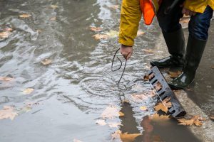 Municipal worker tries to open a drain in Tirana. (Photo: MoT/Facebook) 